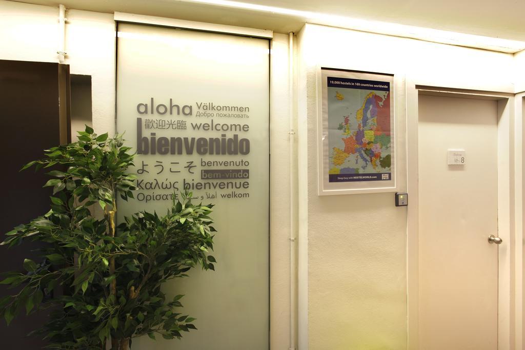 Gracia City Hostel Barcelona Exterior photo Aloha written in several languages at the entrance of a hotel in Geneva